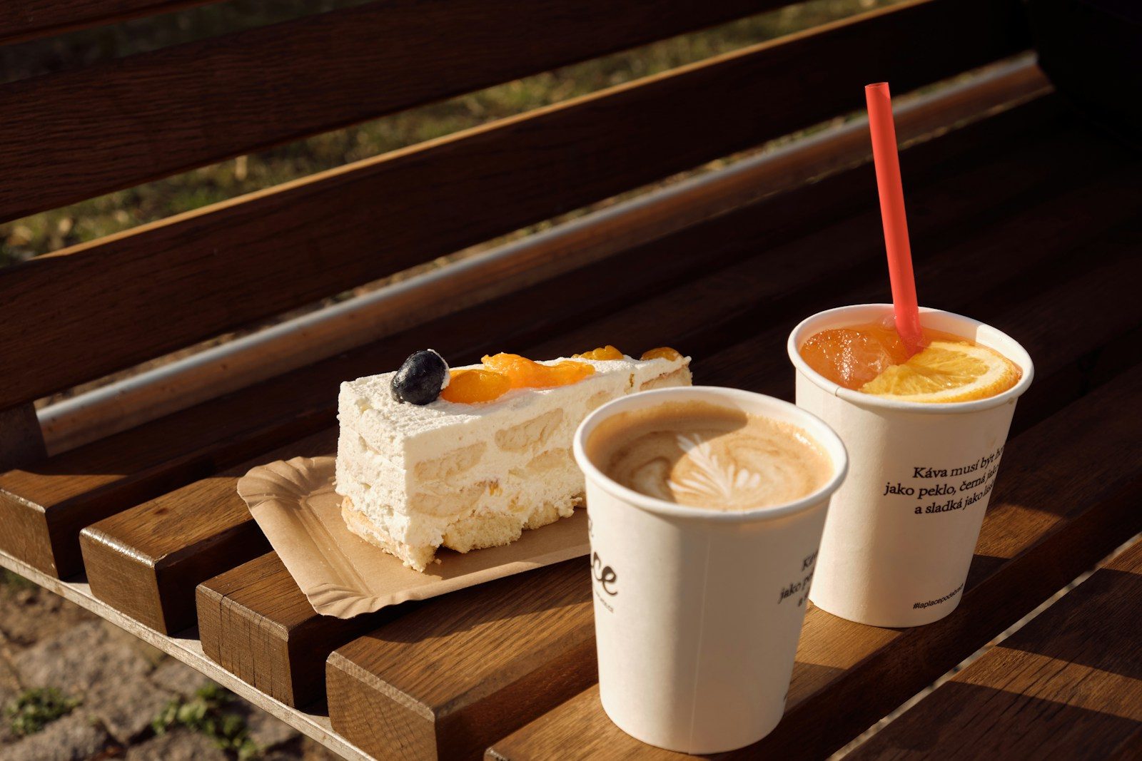 Cake, coffee and juice on a wooden bench.